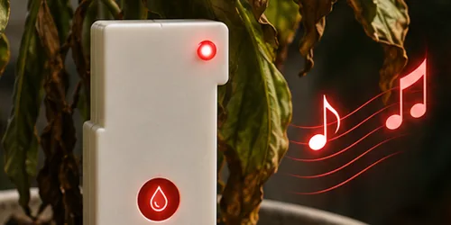 Singer Plant device with a blinking red light and alert sound next to a wilting plant
